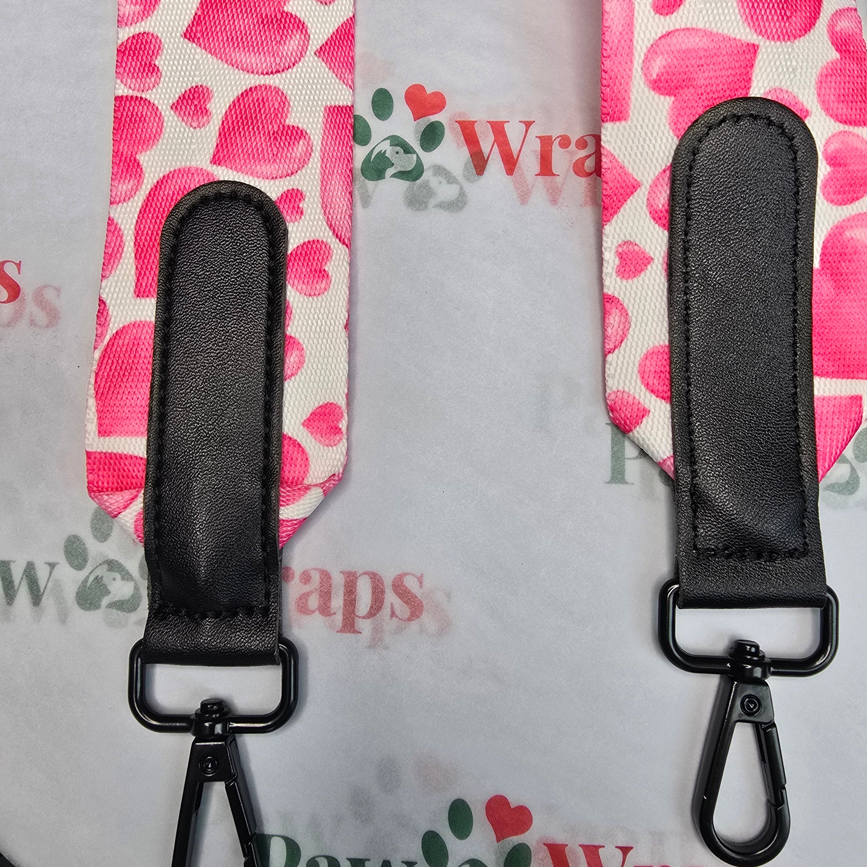 Pink heart-patterned dog leash with black handles and clips
