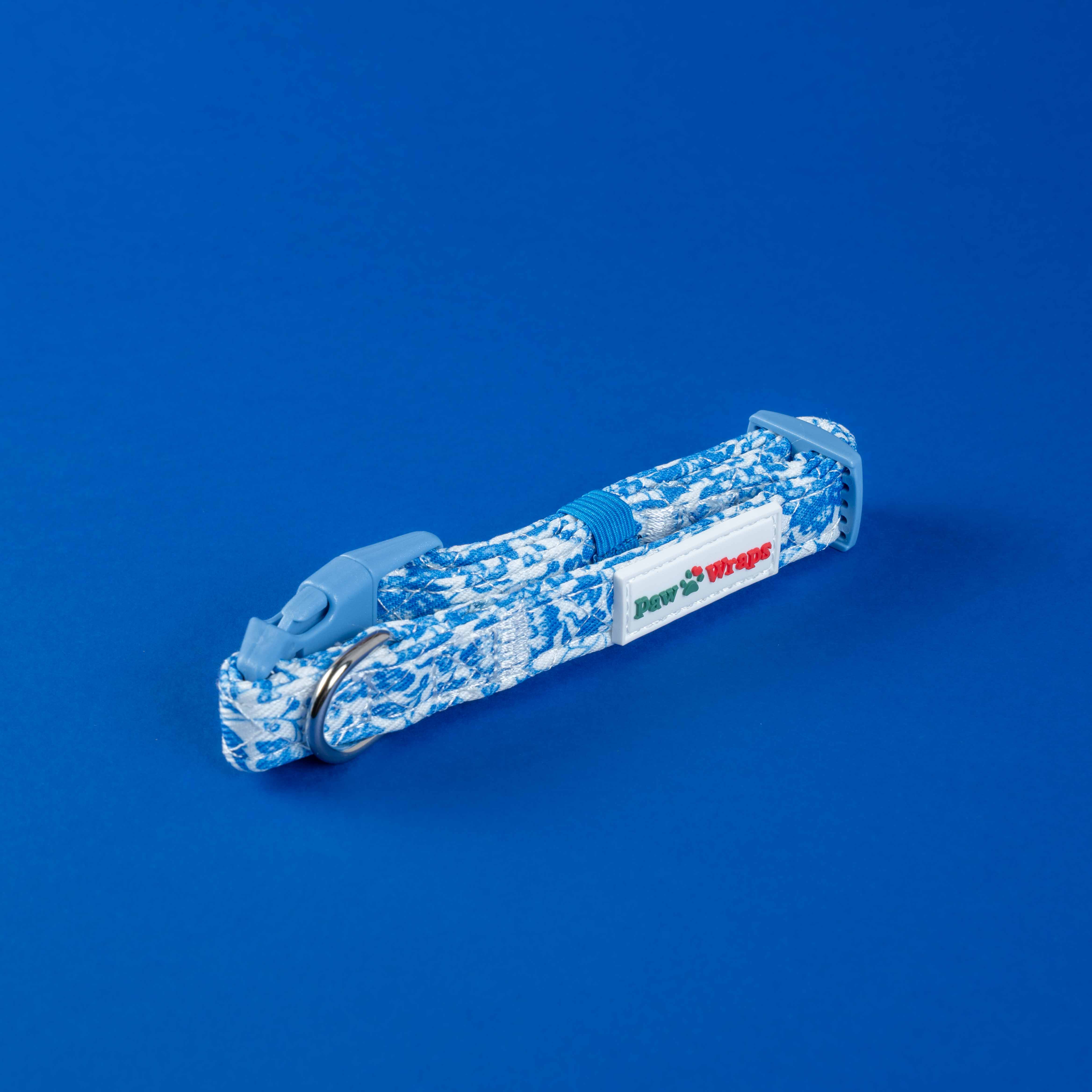 Blue and white patterned dog lead with Paw Wraps label on vibrant blue background