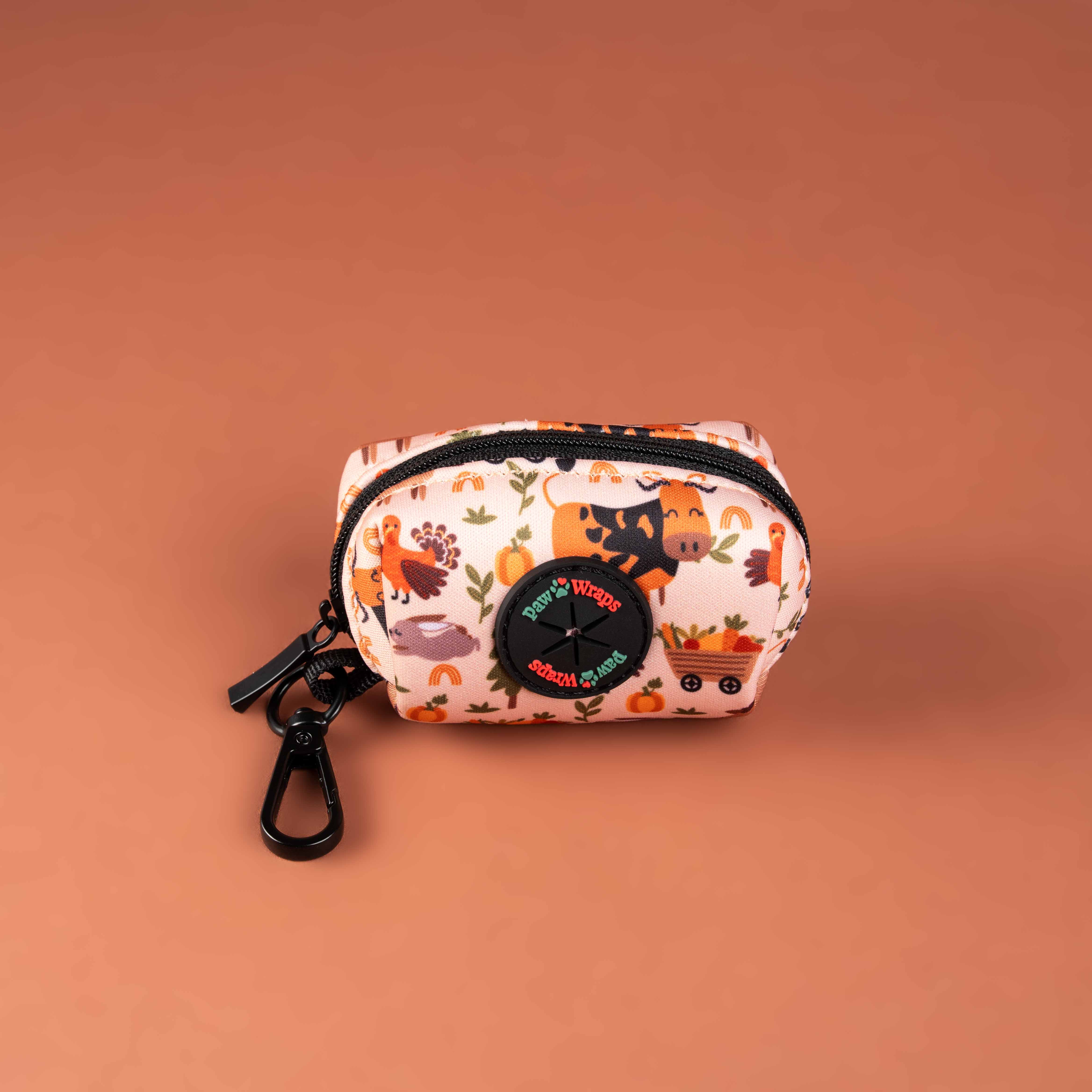 Cute autumn-themed dog accessory bag with farm animal print and black zipper, perfect for walks.