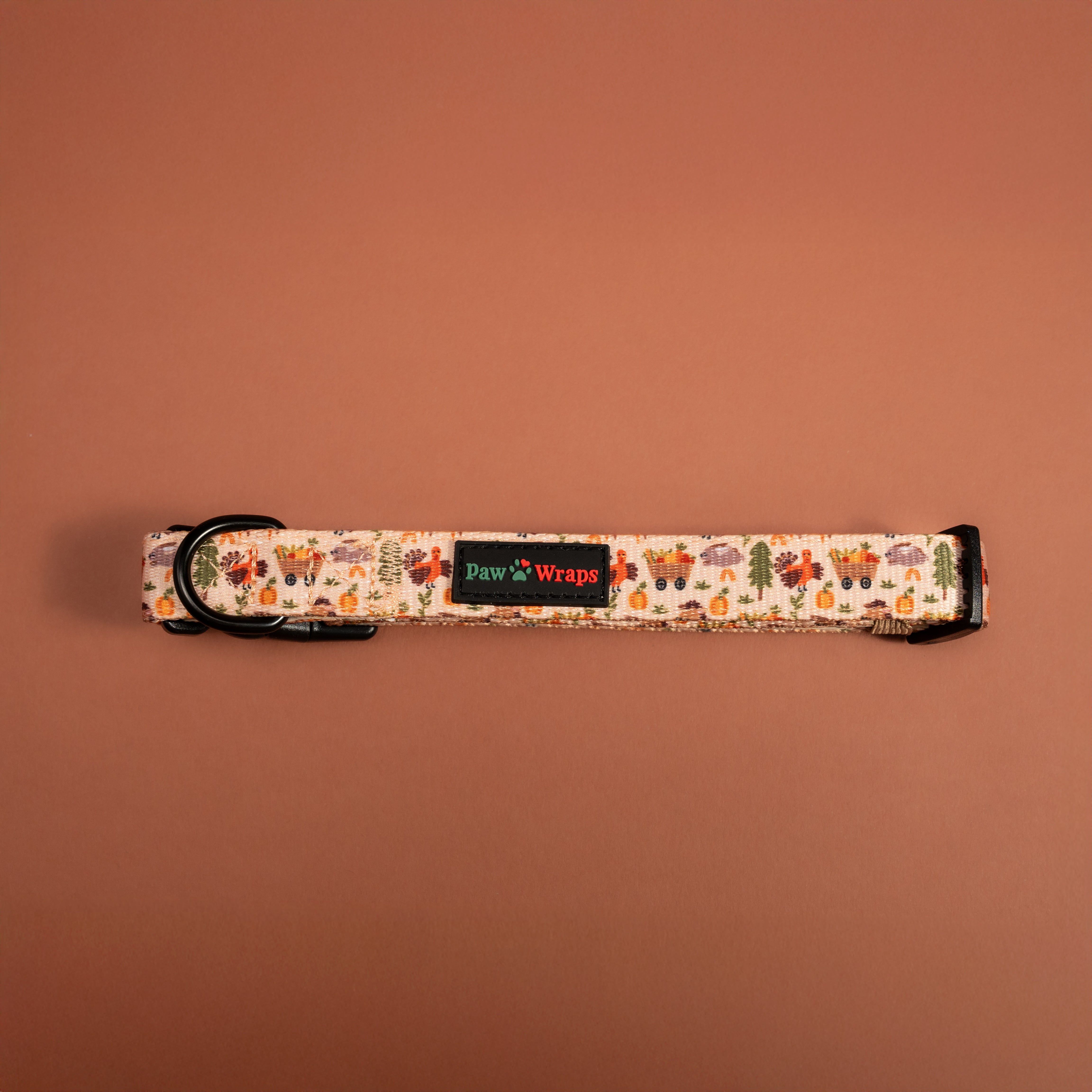Autumn-themed dog collar with turkey, pumpkin, and cart print, black hardware, Paw Wraps brand tag