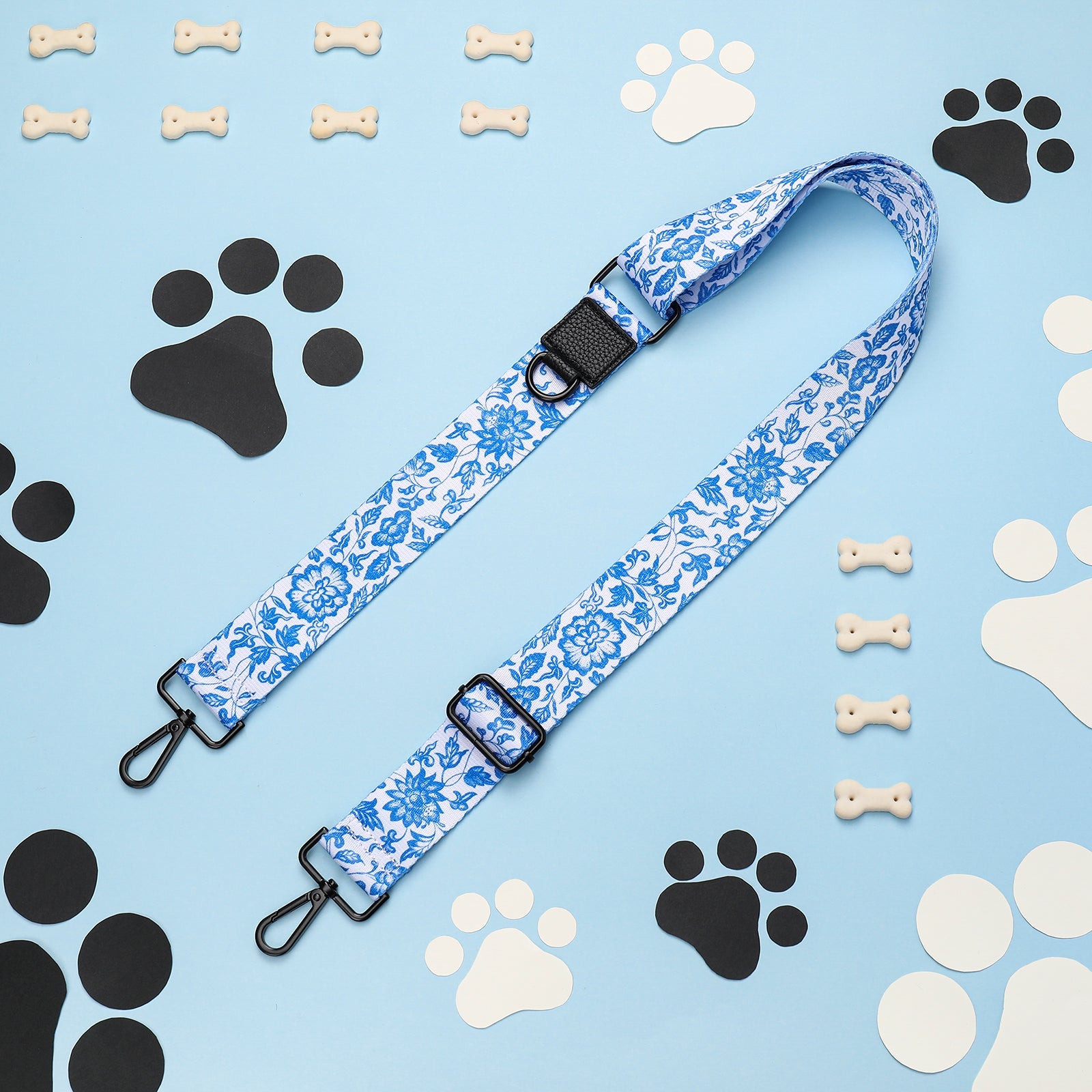 Blue floral dog leash with paw prints and bones on light blue background
