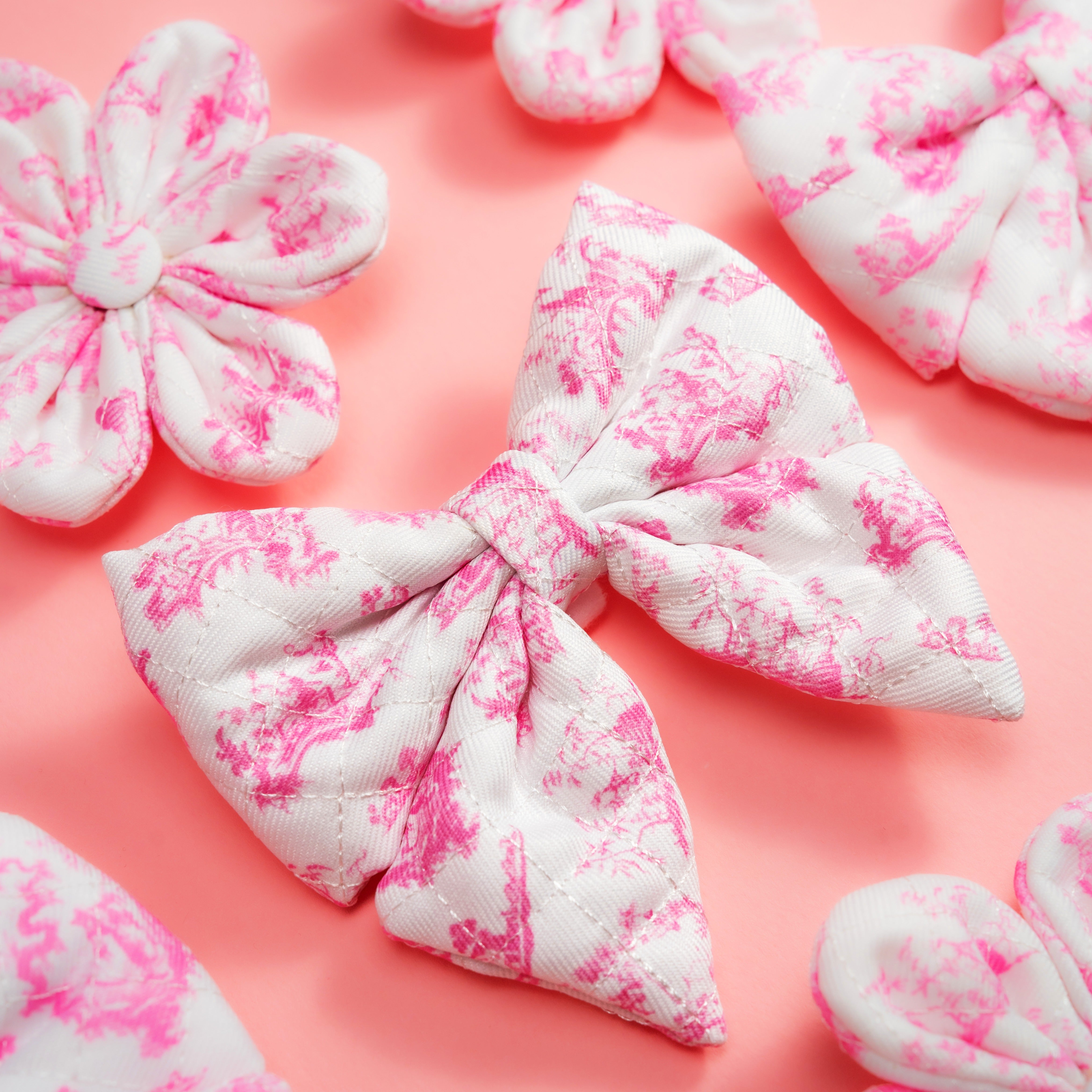 Pink floral dog bow tie accessory on soft pink background