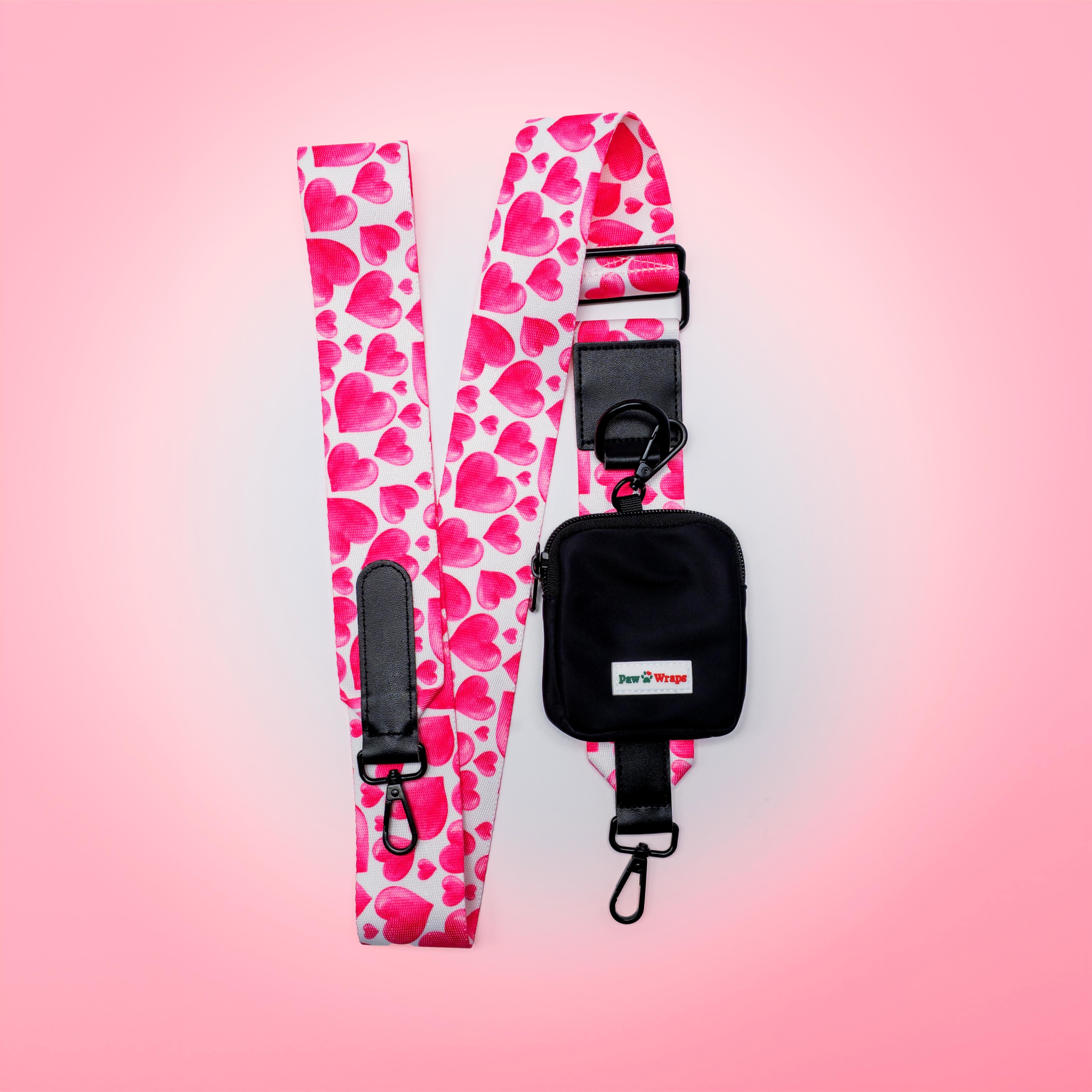 Pink heart-patterned dog walking bag with black pouch and clips, stylish for small dogs