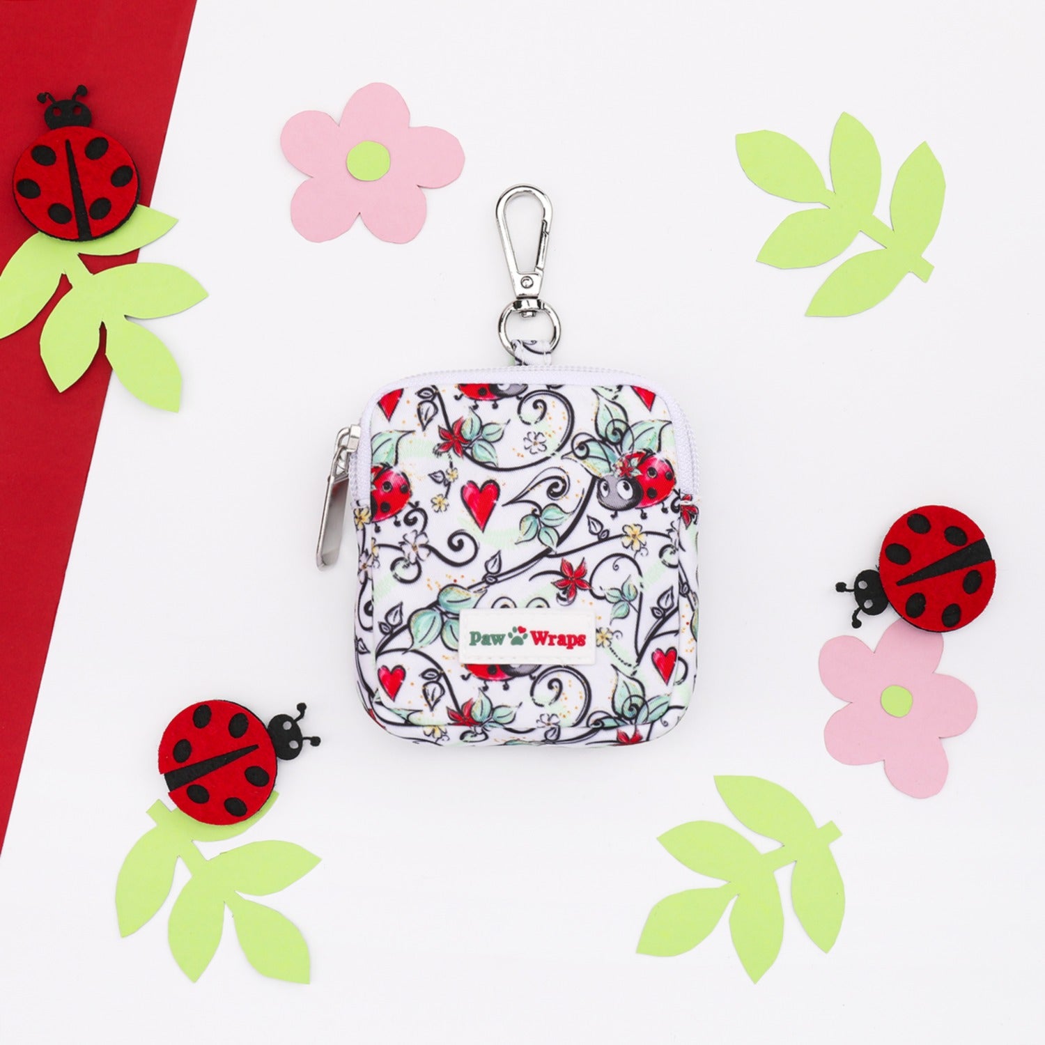 Ladybug print dog accessory pouch with floral design and heart accents, perfect for stylish walks.