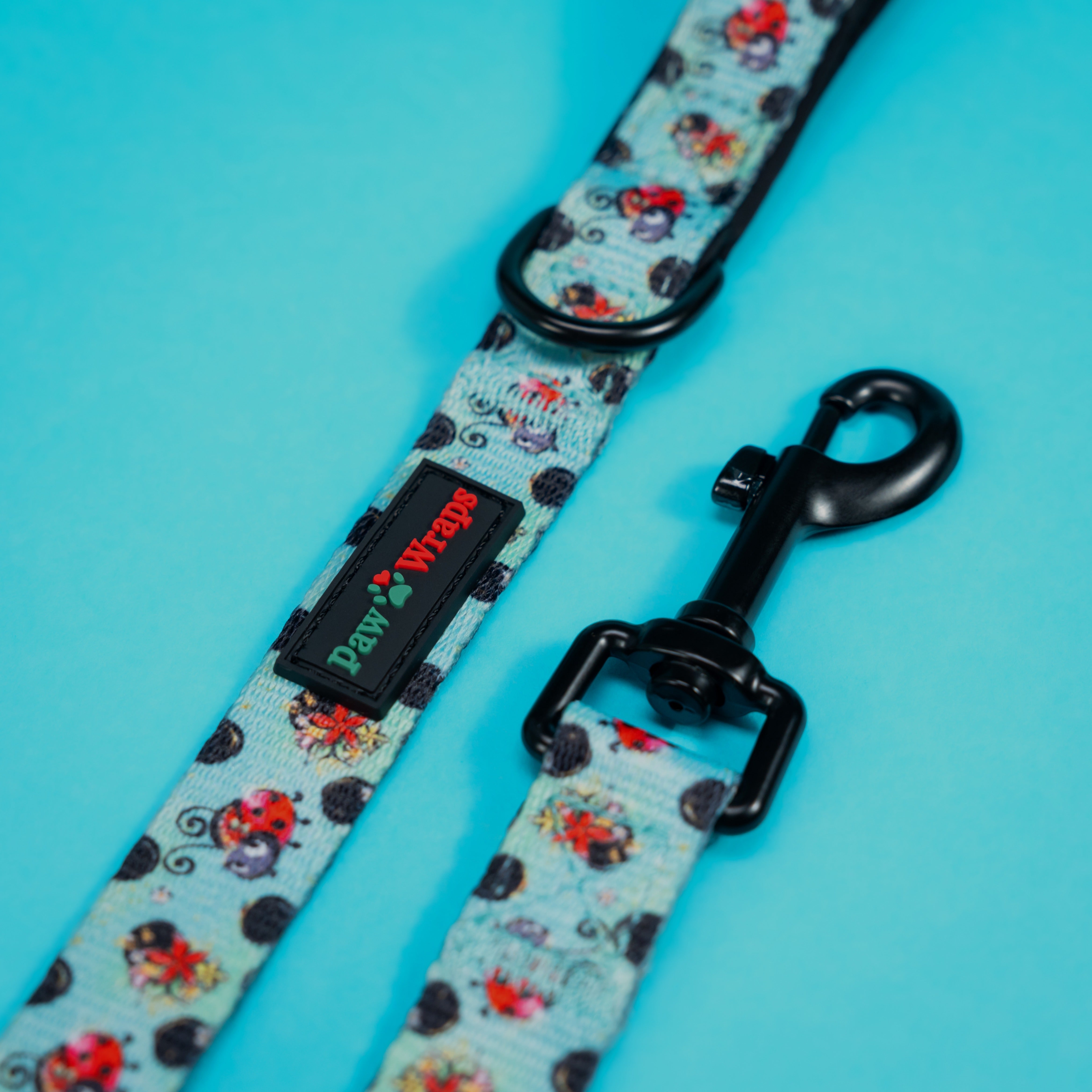 Stylish dog lead with ladybug print and Paw Wraps branding on turquoise background