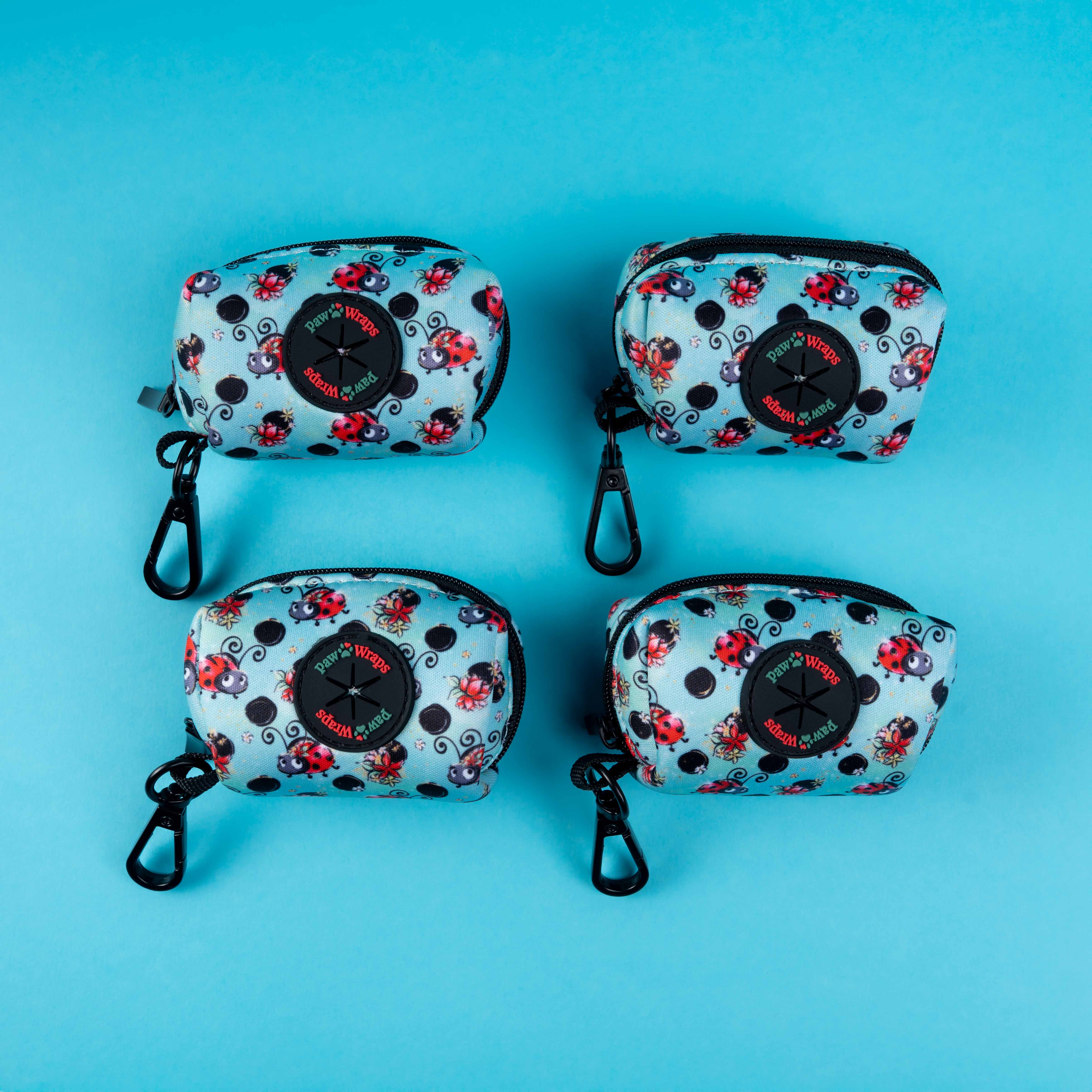 Ladybug print dog waste bag dispensers with black clips on blue background