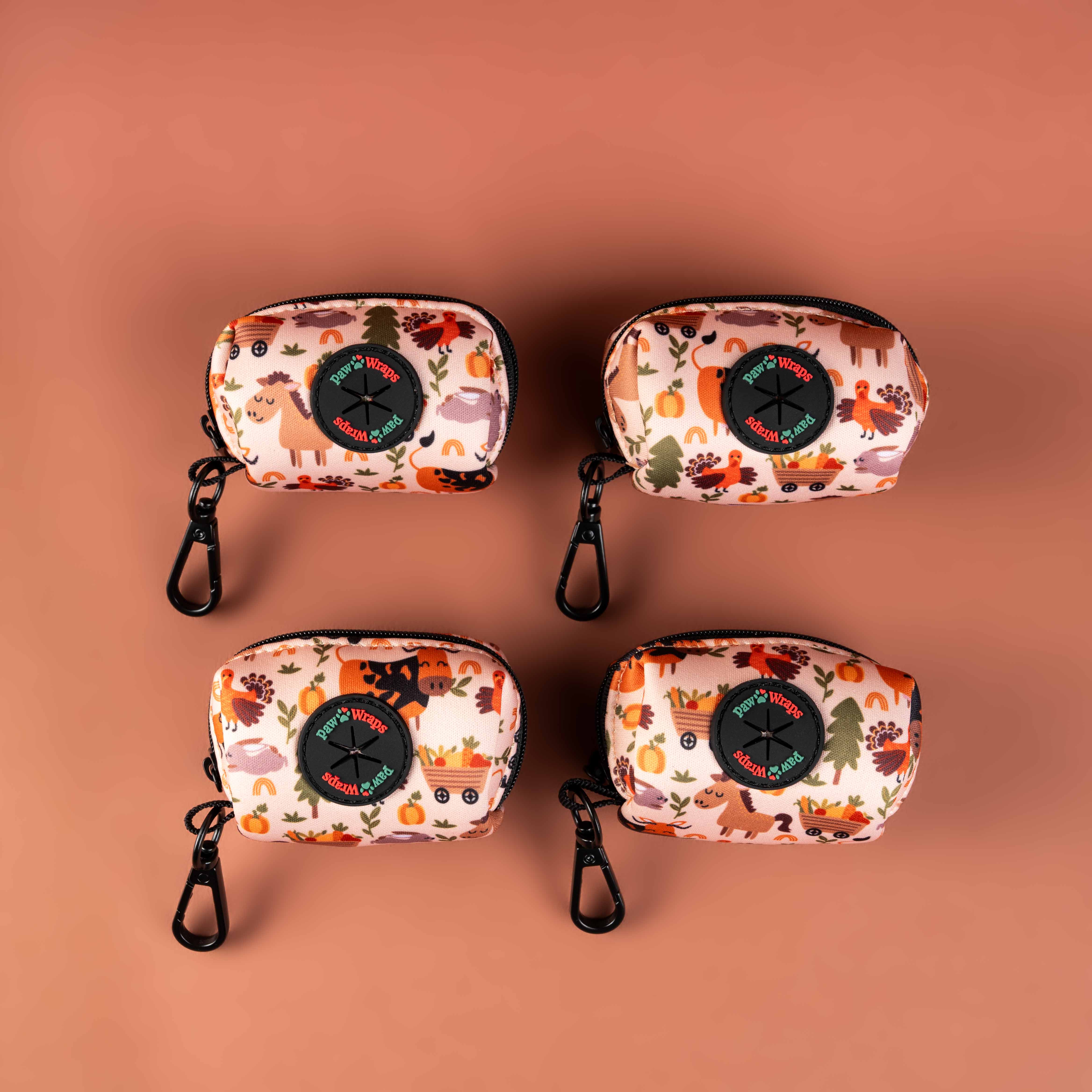 Four autumn-themed dog poop bag dispensers with farm animal prints and carabiner clips